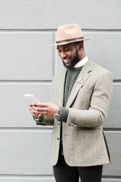 Vue de face homme regardant son téléphone à l'extérieur