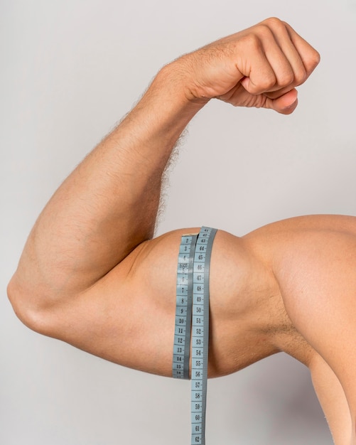 Photo gratuite vue de face de l'homme avec un ruban à mesurer sur les biceps