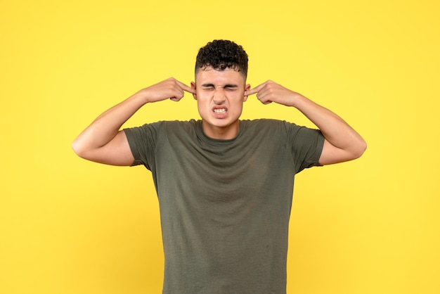 Vue de face de l'homme se couvrit les oreilles avec ses doigts et fronça les sourcils