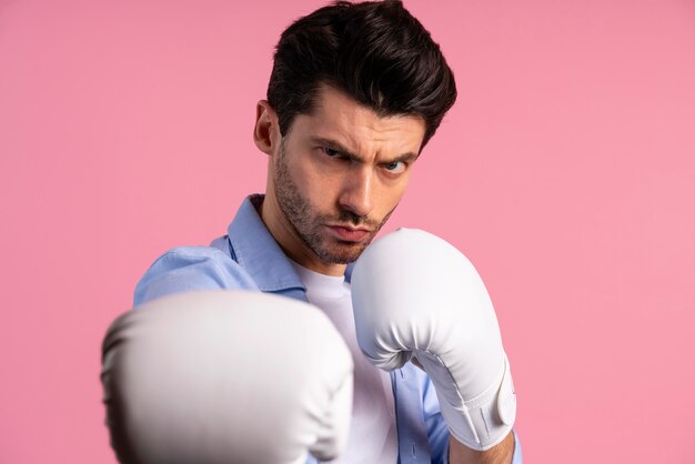 Vue de face d'un homme sérieux avec des gants de boxe prêts à se battre