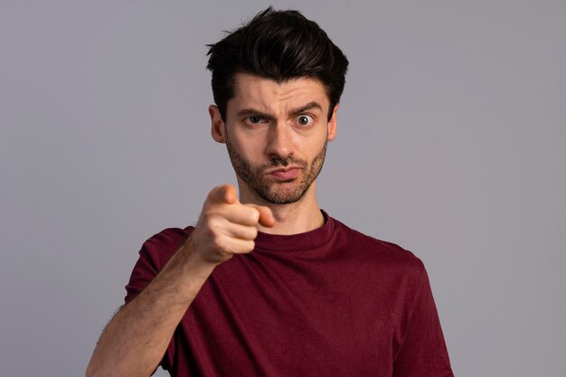 Vue de face de l'homme sérieux pointant vers l'avant