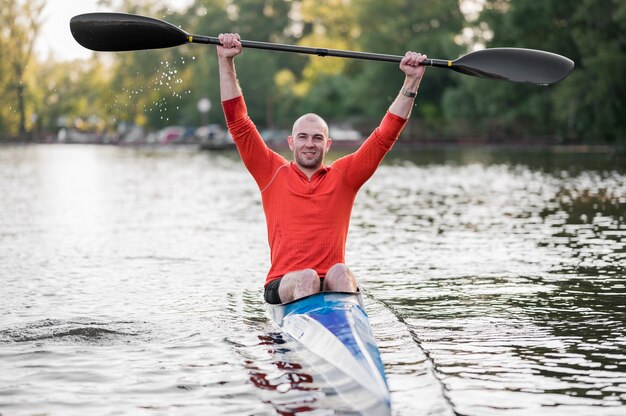 Photo gratuite vue de face homme souriant en canoë avec rame