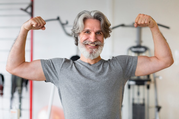 Vue de face homme souriant dans la salle de sport