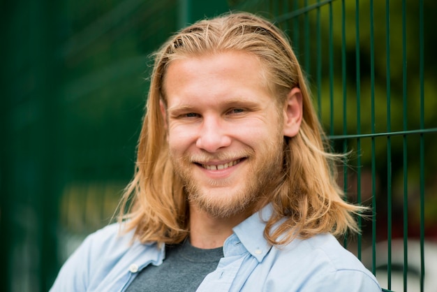 Vue de face de l'homme souriant à l'extérieur