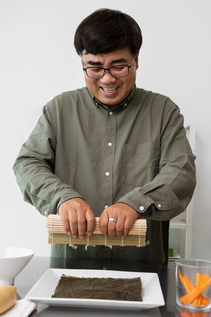 Vue de face homme souriant faisant des sushis