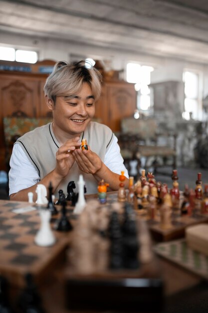 Vue de face homme souriant jouant aux échecs