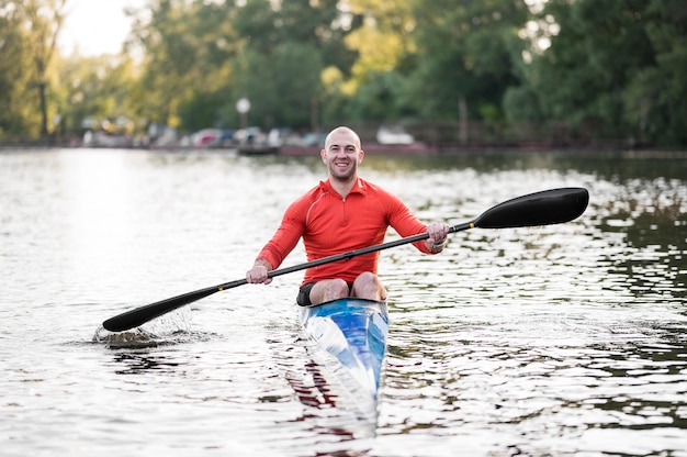 Vue de face homme souriant en kayak avec rame