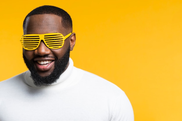 Vue de face homme souriant avec lunettes de soleil