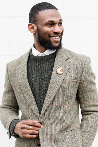 Vue de face homme souriant posant dans des vêtements formels