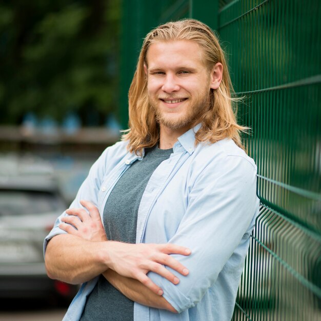 Vue de face de l'homme souriant posant à l'extérieur