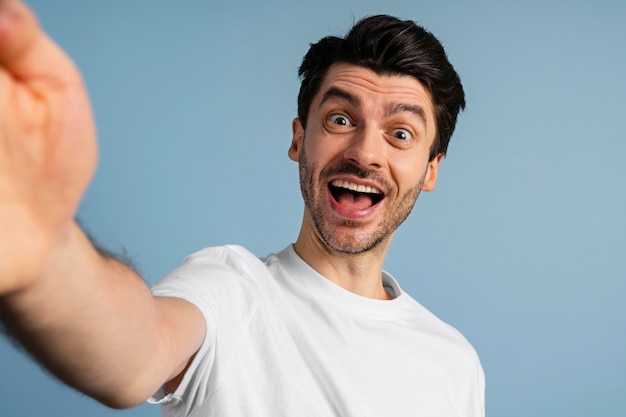 Vue de face de l'homme souriant prenant un selfie