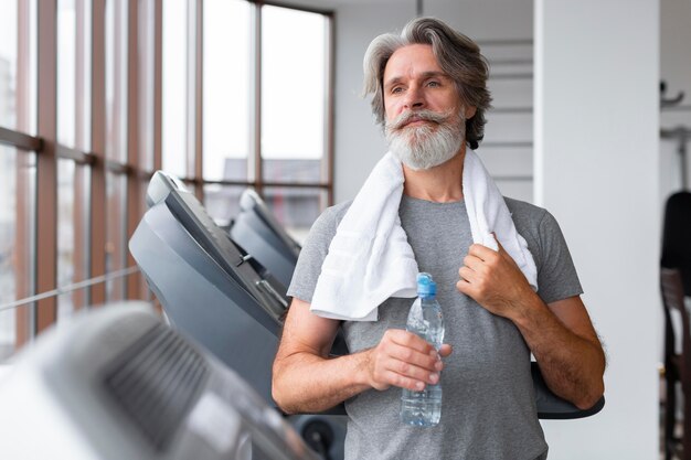 Vue de face homme tenant une bouteille d'eau