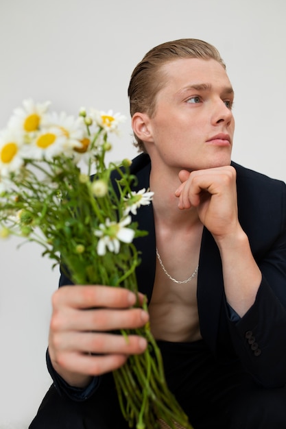 Vue de face homme tenant des fleurs