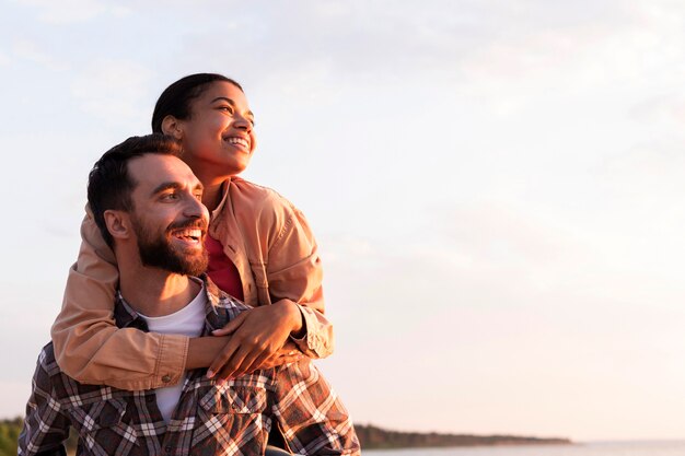 Vue de face homme tenant sa petite amie sur le dos avec copie espace