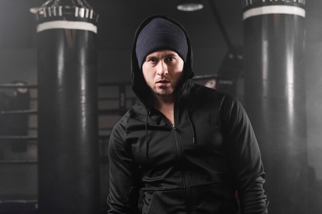 Vue de face homme en tenue de sport au centre d'entraînement de boxe