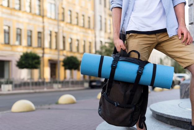 Vue de face de l'homme touristique tenant le sac à dos