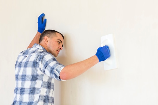 Photo gratuite vue de face d'un homme travaillant sur un mur