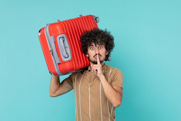 Vue de face homme en vacances tenant son gros sac sur bleu