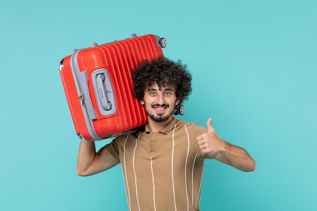 Vue de face homme en vacances tenant son gros sac avec sourire sur bleu