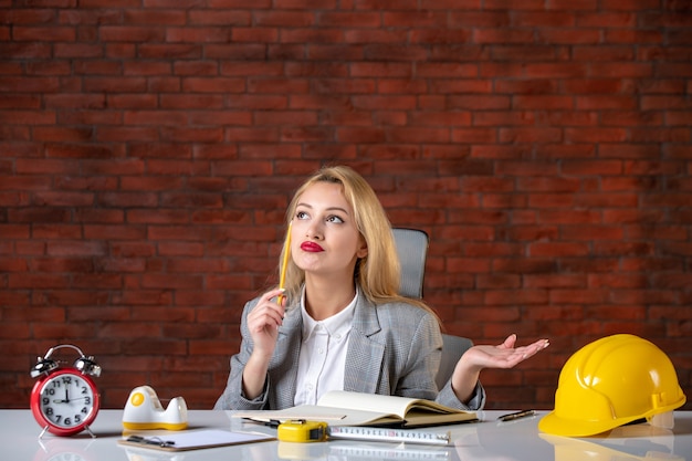 Vue De Face Ingénieur Féminin Pensant Assis Au Bureau