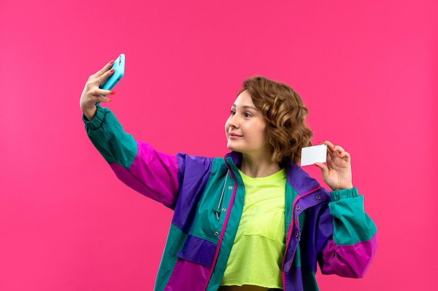 Une vue de face jeune belle dame en chemise de couleur acide pantalon noir veste colorée prenant selfie smiling