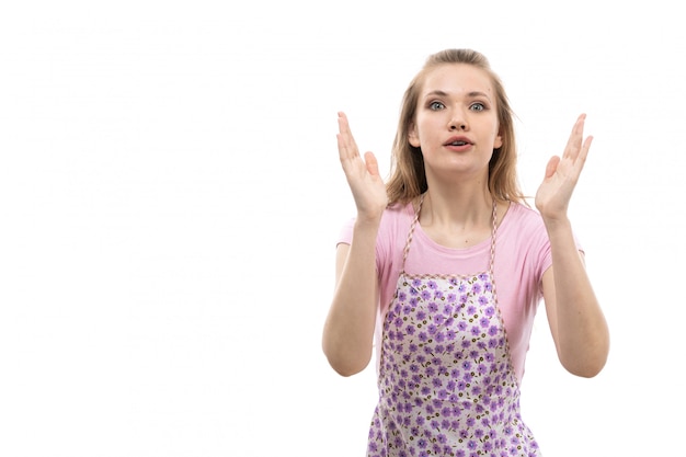 Une vue de face jeune belle femme au foyer en chemise rose cape colorée surpris posant