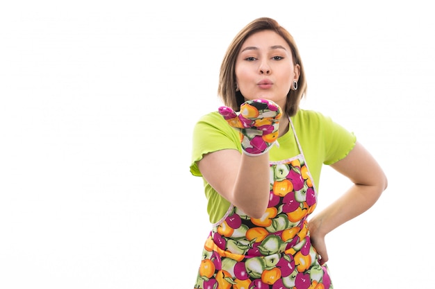 Une vue de face jeune belle femme au foyer en chemise verte cape colorée envoyant des baisers d'air sur le fond blanc maison nettoyage cuisine