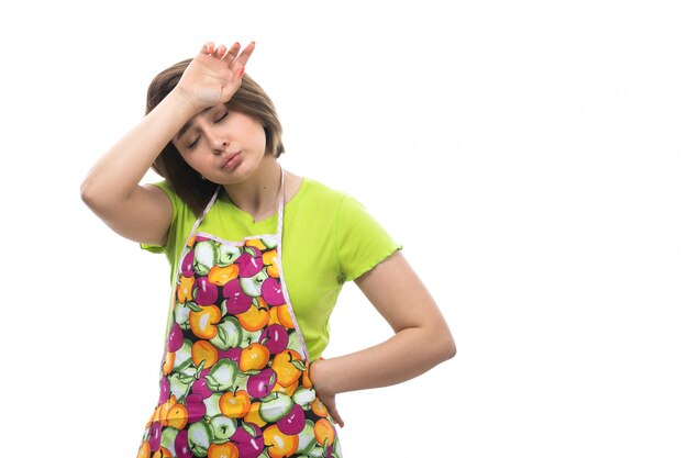 Une vue de face jeune belle femme au foyer en chemise verte cape colorée fatigué épuisé en raison des travaux ménagers