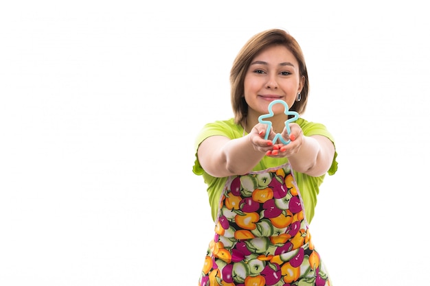 Une vue de face jeune belle femme au foyer en chemise verte cape colorée tenant la forme de la figure humaine bleue souriant sur le fond blanc maison nettoyage cuisine