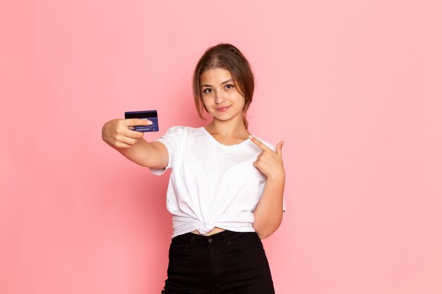 Une vue de face jeune belle femme en chemise blanche avec carte mauve holding