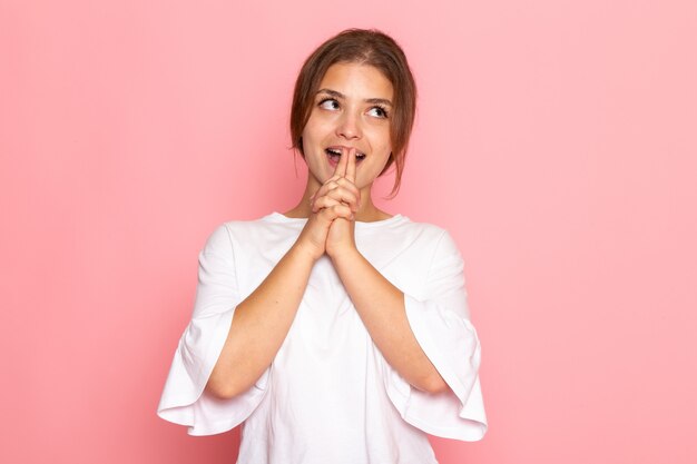 Une vue de face jeune belle femme en chemise blanche posant avec une expression ravie