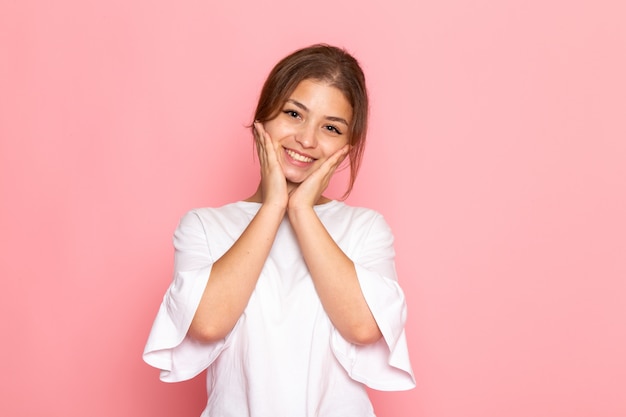 Une vue de face jeune belle femme en chemise blanche posant avec une expression ravie