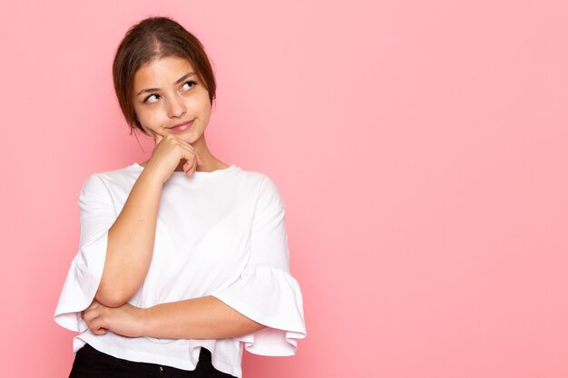 Une vue de face jeune belle femme en chemise blanche posant avec une expression de rêve