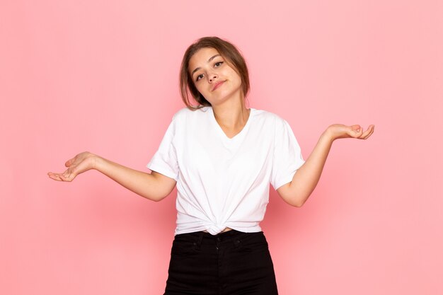 Une vue de face jeune belle femme en chemise blanche posant avec je ne sais pas l'expression