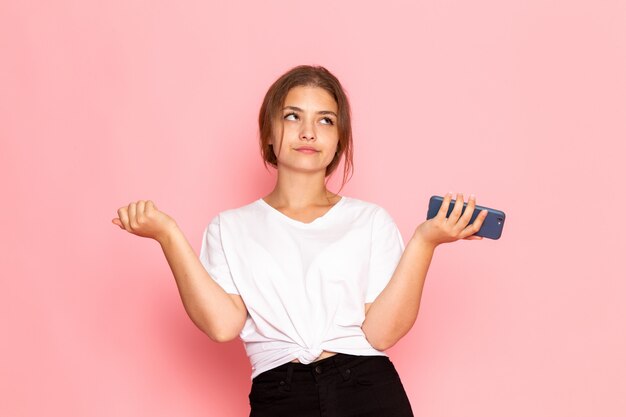 Une vue de face jeune belle femme en chemise blanche tenant un téléphone