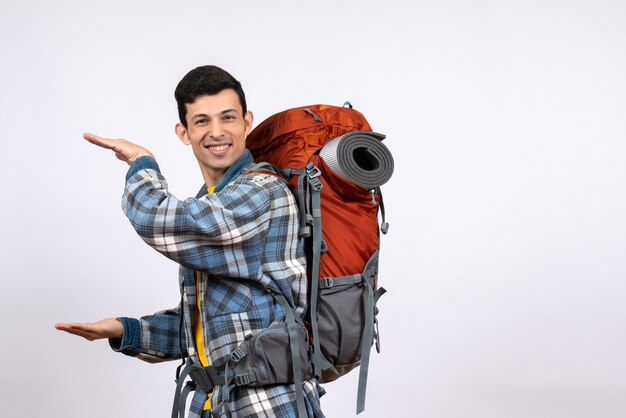 Vue de face jeune campeur avec sac à dos montrant la taille avec les mains