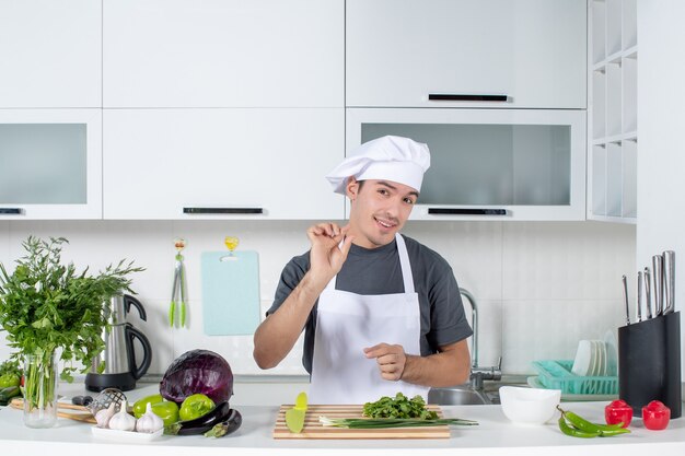 Vue de face jeune chef en chapeau de cuisinier