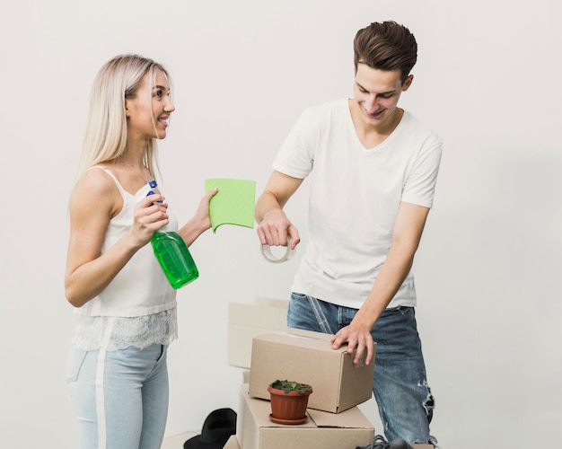 Vue de face jeune couple avec boîtes de déménagement