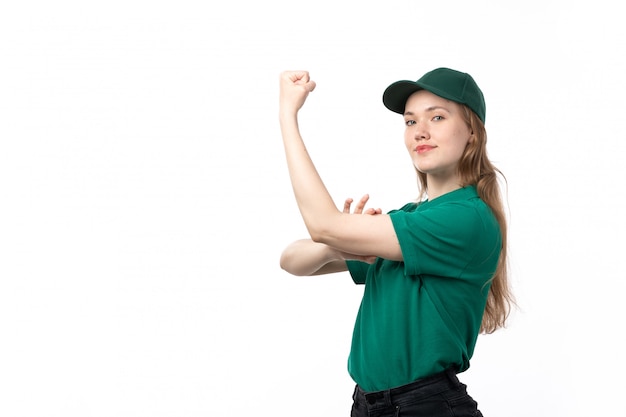 Une vue de face jeune courrier en uniforme vert souriant et fléchissant