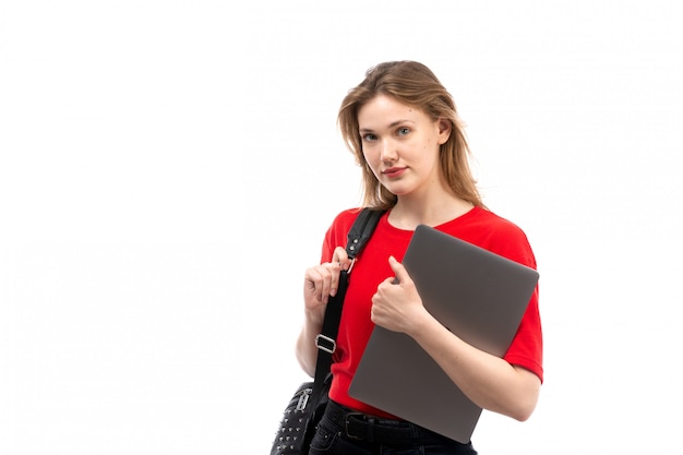 Une vue de face jeune étudiante en chemise rouge sac noir contenant des fichiers sur le blanc