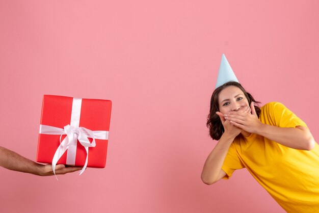 Vue de face jeune femme acceptant présent du mâle sur le rose