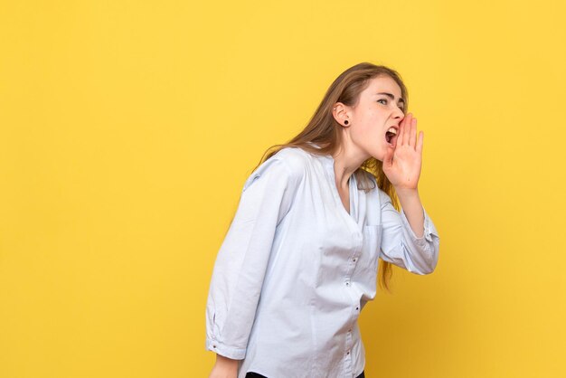 Vue de face d'une jeune femme appelant fort