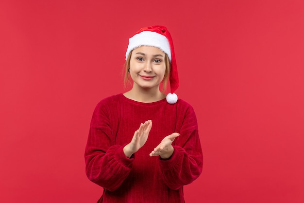 Vue de face jeune femme applaudissant avec sourire, vacances de Noël rouge