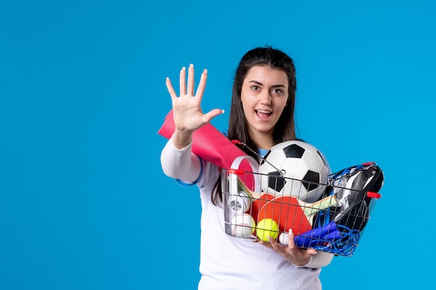 Vue de face jeune femme après le sport shopping sur mur bleu