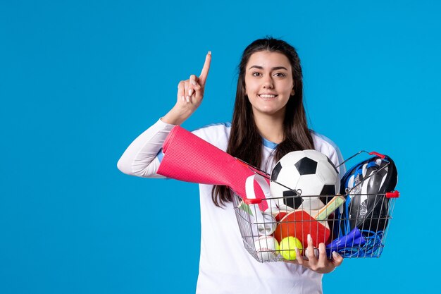 Vue de face jeune femme après le sport shopping sur mur bleu