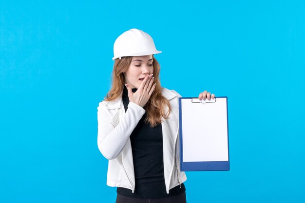 Vue de face jeune femme architecte holding file note