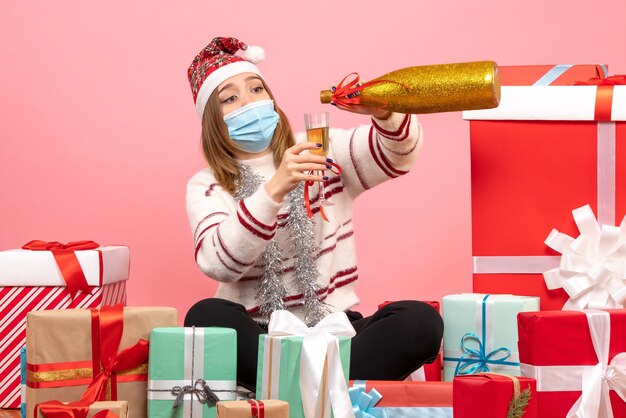 Vue de face jeune femme assise autour de cadeaux et célébrant