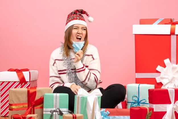 Vue de face jeune femme assise autour de cadeaux