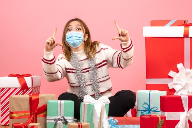 Vue de face jeune femme assise autour de cadeaux