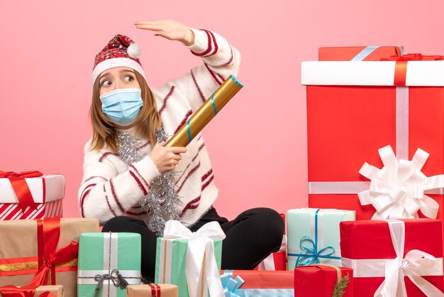 Vue de face jeune femme assise autour de cadeaux